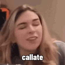 a close up of a woman with her eyes closed and the words callate written on her face .