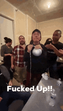 a man is holding a kettlebell in a room with the words fucked up written on the bottom