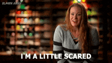 a woman in a sweater is saying i 'm a little scared in a store .