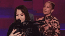 a woman singing into a microphone wearing a shirt that says epine
