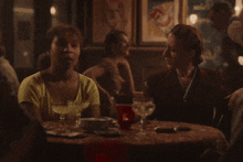 two women sit at a table with a martini glass