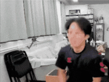 a man in a black shirt with a red letter b on it