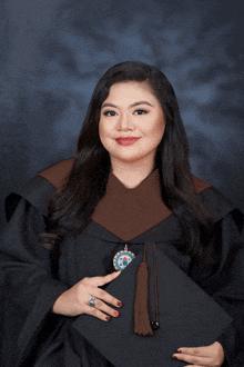 a woman in a graduation gown holds her cap