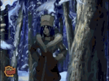 a woman in a fur coat is standing in a snowy forest with a tele toon logo in the corner