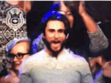a man with a beard wearing a blue helmet is surrounded by people