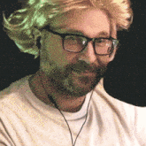 a man wearing a wig and glasses is smiling