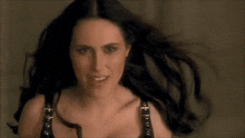 a woman with long black hair wearing a black bra
