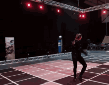 a person is dancing in front of a sign that says ' ultimate combat ' on it
