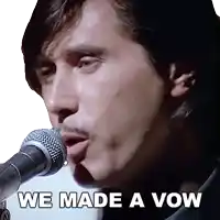 a man singing into a microphone with the words we made a vow next to him