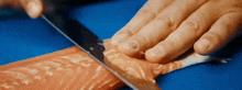 a close up of a person cutting a piece of salmon with a knife .