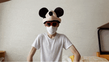 a man wearing a mickey mouse hat and heart shaped sunglasses