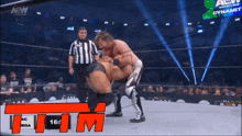 a wrestling match is being shown on a screen that says aew