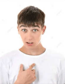 a young man in a white t-shirt is pointing at his chest .