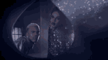 a man and a woman are looking at each other through a mirror