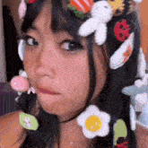 a close up of a girl wearing a hat with a bunch of stuffed animals in her hair .