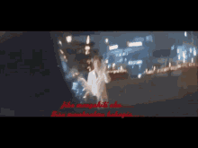a blurry picture of a woman standing in front of a city at night