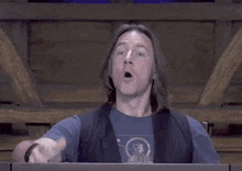 a man with long hair and a blue shirt says bidet in yellow letters
