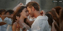 a man and a woman are dancing in front of a crowd and the words pranay varma are visible