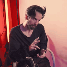a man with a beard is sitting in a chair