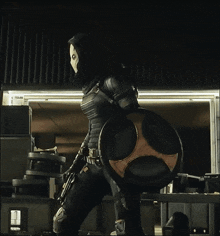 a man in a mask is holding a shield