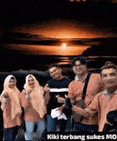 a group of people posing for a picture with the words kiki terbang sukses mo