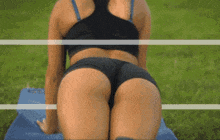 a woman is sitting on a yoga mat in the grass .