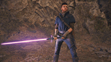 a man is holding a purple light saber in a cave
