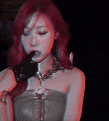 a woman with red hair is wearing a black glove and a necklace