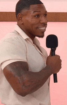 a man in a white shirt holds a black microphone