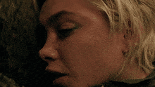 a close up of a woman 's face with a green eye