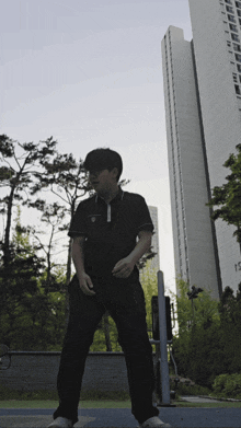 a man stands in front of a tall building that has the number 15 on it
