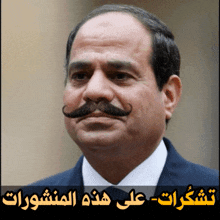 a man with a mustache is standing in front of arabic writing