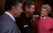 a woman wearing a pink sweater has a name tag that says mike