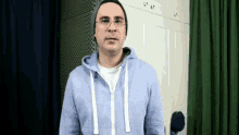 a man wearing glasses and a beanie is standing in a room