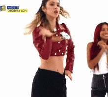 two women are dancing in front of a sign that says katseye on it