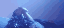 a woman is laying down in a dark room with a blue light behind her