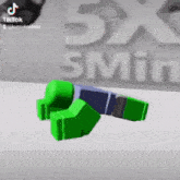 a green toy is laying on the ground in front of a sign that says 5x 5 min .