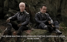 two men are sitting on a rock in the woods and waiting for the chipendale scum to be done .