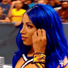 a woman with blue hair is talking on a phone