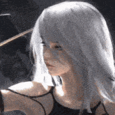 a girl with white hair is wearing a black tank top and looking at the camera .