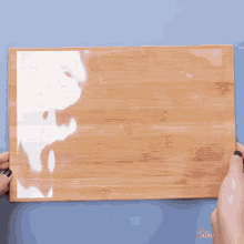 chocolate is being poured into a measuring cup on a wooden surface