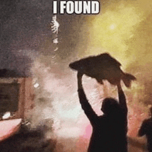 a man is holding a large fish in his hands in front of a crowd .