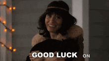 a woman is holding a black cat with the words good luck on written below her
