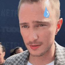 a close up of a man 's face with a drop of water on his forehead