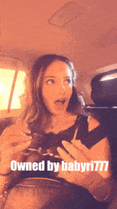 a woman sitting in the back seat of a car with the words owned by babyri777 above her