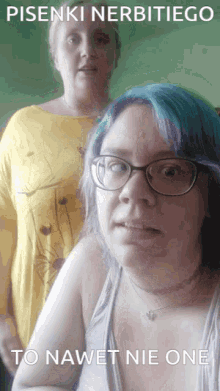 a woman with blue hair and glasses is standing next to another woman with blonde hair