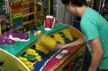 a man in a green shirt is playing a video game with a hippo on it .