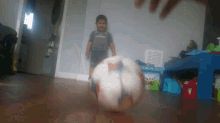 a young boy wearing an emirates shirt is playing with a ball