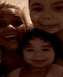 a woman and two children are posing for a photo