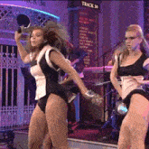 two women are dancing in front of a sign that says track 30 on it